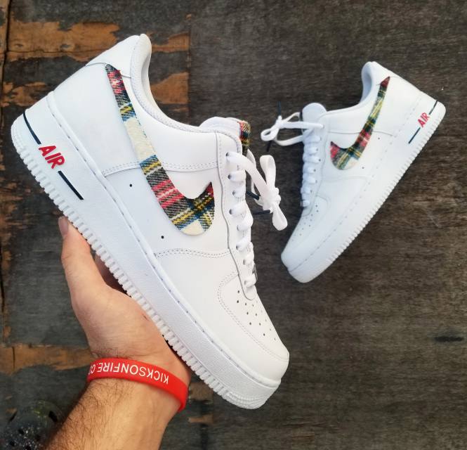 Hand-painted plaid-swoosh Air Force 1s held up in the OPC Kicks workshop